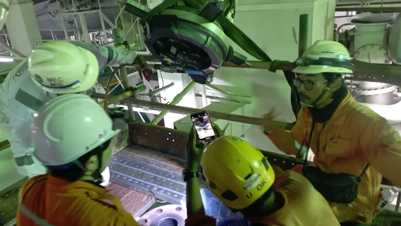 Technicians inspecting machinery in an industrial workspace